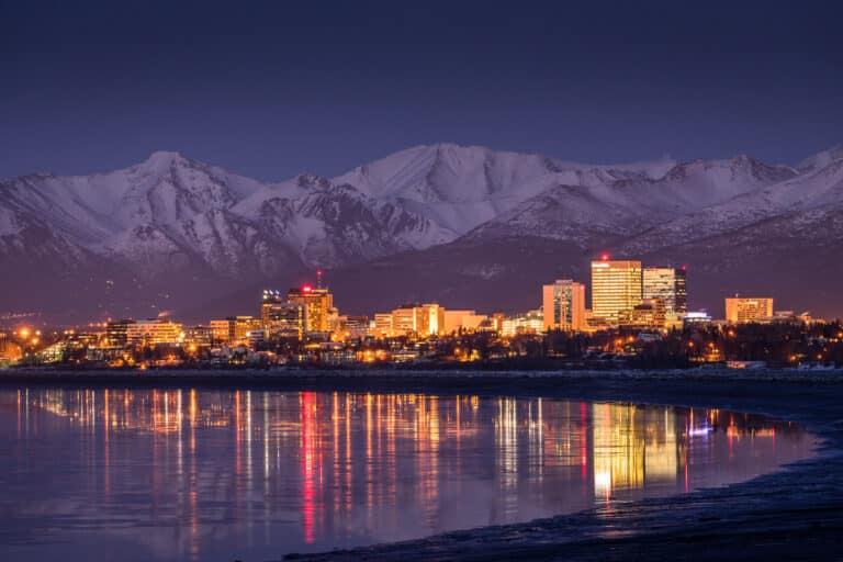 Anchorage city lights reflecting on Cook Inlet at twilight